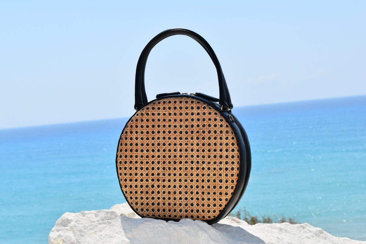 ILHA Francesca handwoven rattan handbag, black, sea backdrop